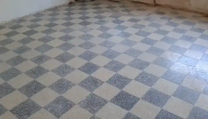 Worn terrazzo floor with dull patches and visible traffic wear